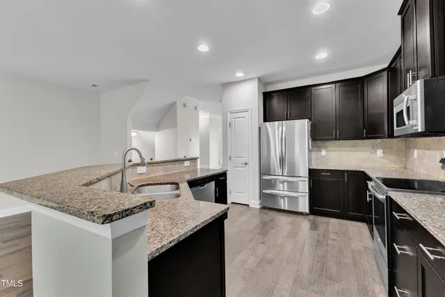a kitchen with granite countertop a refrigerator and a sink