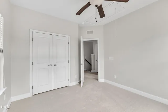 a view of a livingroom with a ceiling fan & entryway