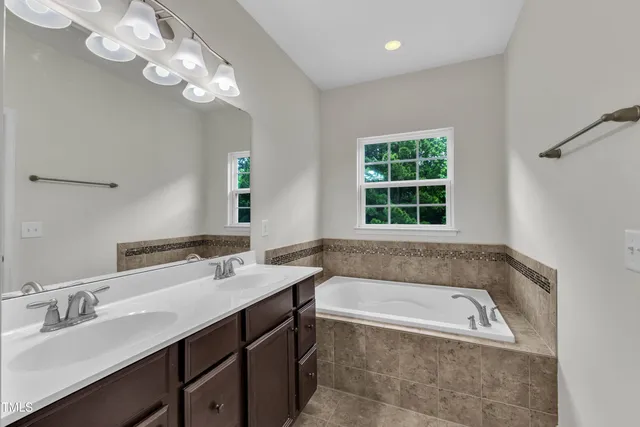 a bathroom with a bathtub a sink and a window
