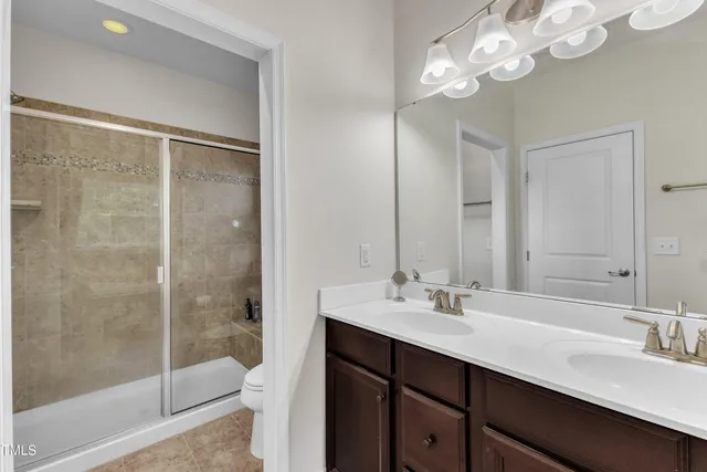 a bathroom with a double vanity sink mirror and toilet