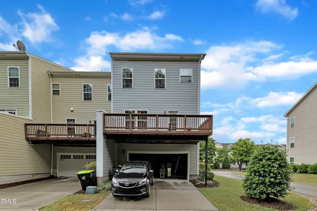 a patio with table and chairs and potted plants