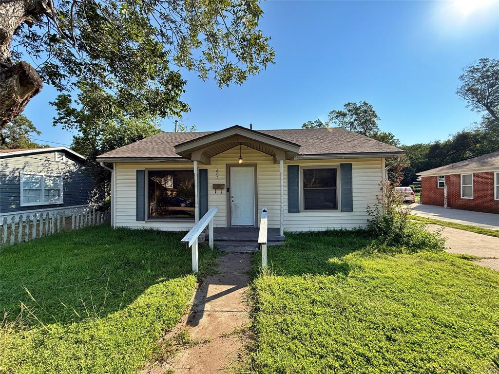 Bungalow-style house with roof with shingles and a front lawn