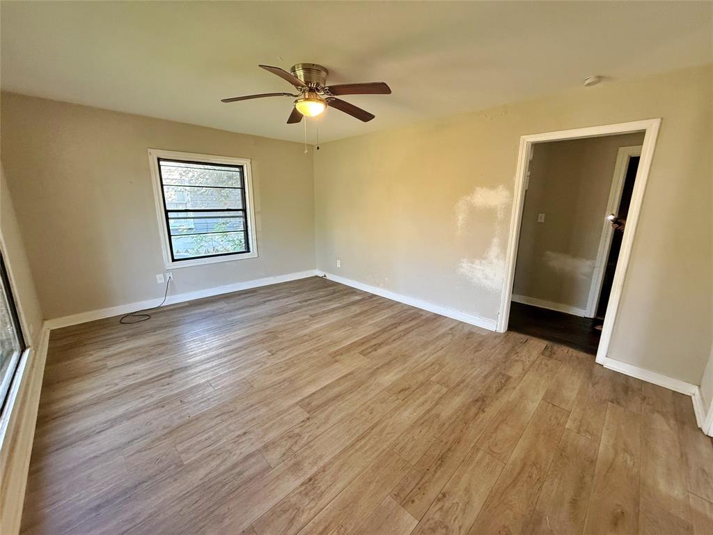 607 La Clede Street Bellmead, TX 76705 - Photo 3 of 7 Empty room with light wood-style flooring and ceiling fan