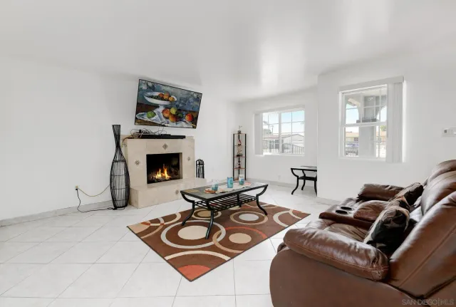 a living room with furniture a fireplace and a flat screen tv