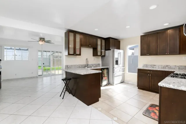 a kitchen with kitchen island granite countertop a stove a sink a microwave a counter top and cabinets