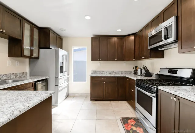 a kitchen with stainless steel appliances granite countertop a stove a sink and a microwave