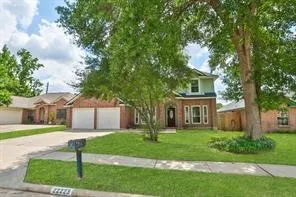 a front view of a house with a yard and tree