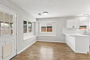 a view of a kitchen with wooden floor and a window