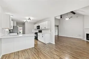 a large kitchen with cabinets wooden floor and stainless steel appliances