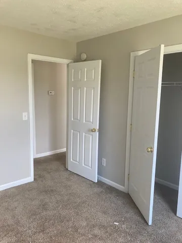 an empty room with windows and chandelier fan