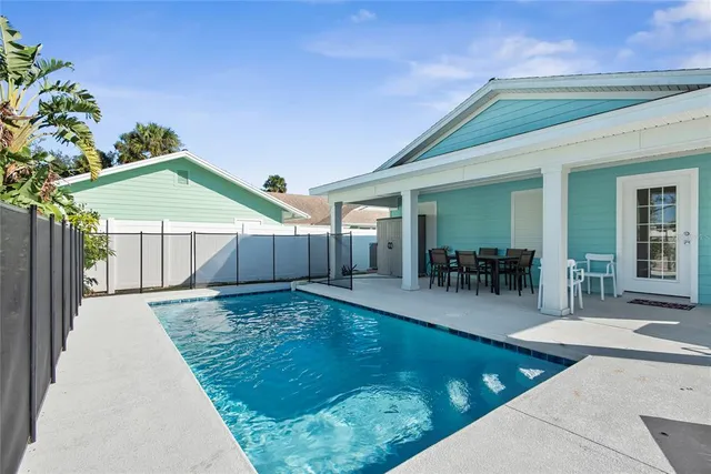 a swimming pool with outdoor seating and yard