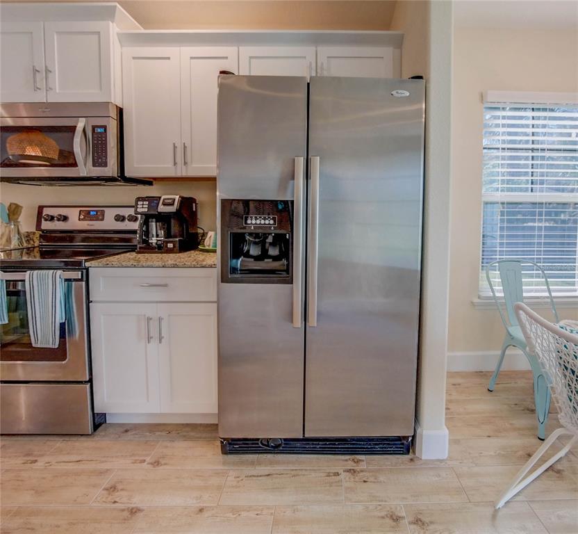 27 Mala Compra Road Palm Coast, FL 32137 - Photo 22 of 57 a kitchen with a refrigerator and a stove