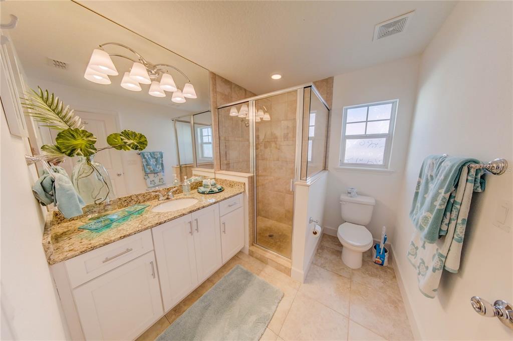 27 Mala Compra Road Palm Coast, FL 32137 - Photo 43 of 57 a spacious bathroom with a granite countertop sink a toilet and a shower