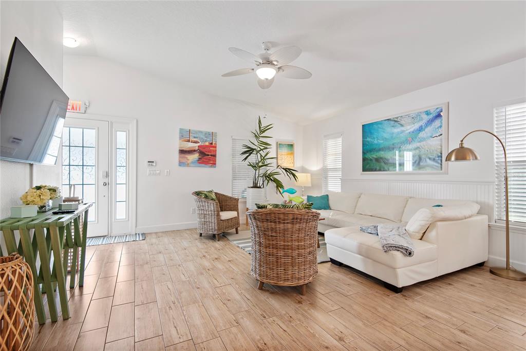 27 Mala Compra Road Palm Coast, FL 32137 - Photo 5 of 57 a living room with furniture a flat screen tv and a floor to ceiling window
