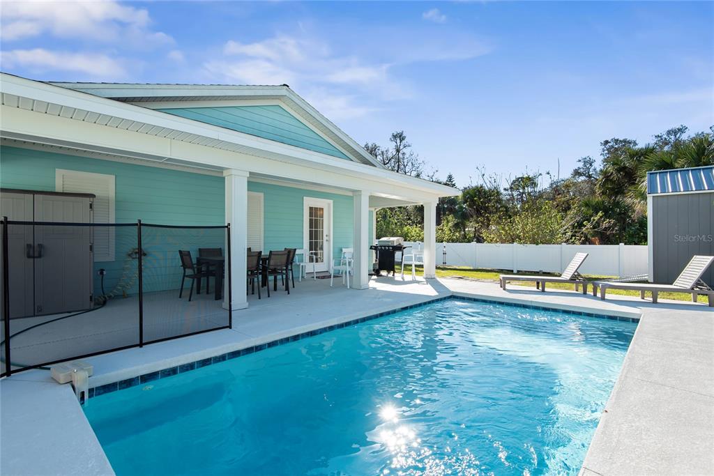 27 Mala Compra Road Palm Coast, FL 32137 - Photo 52 of 57 a view of a swimming pool with potted plants and couches chairs