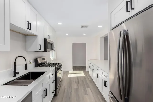a kitchen with granite countertop a refrigerator and a sink