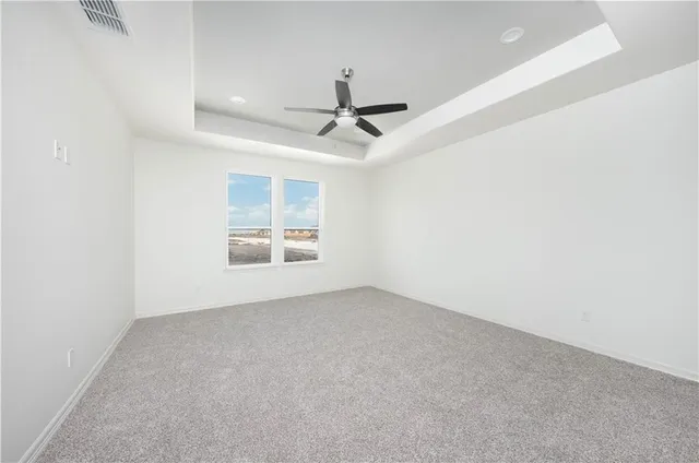 an empty room with a ceiling fan and window