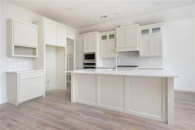 a kitchen with white cabinets and white appliances