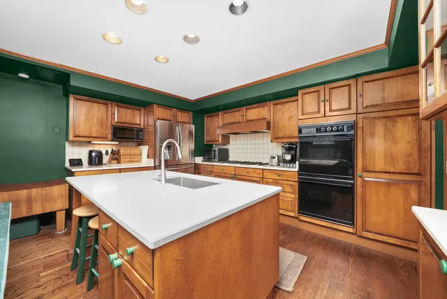 a kitchen with a refrigerator a stove top oven a counter space and a window