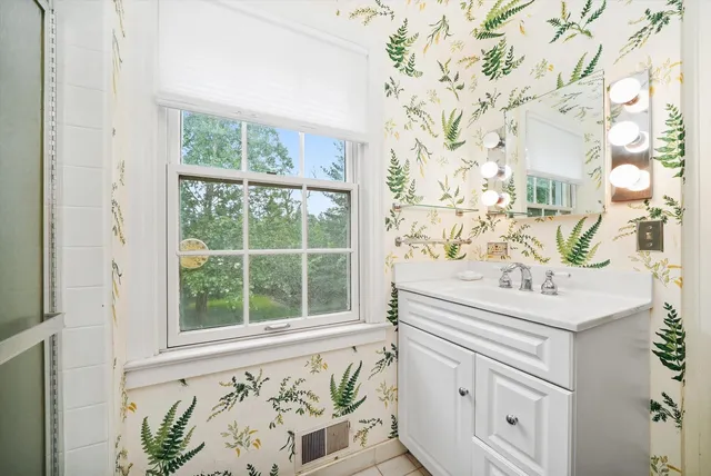 a bathroom with a sink a mirror and a shower curtain