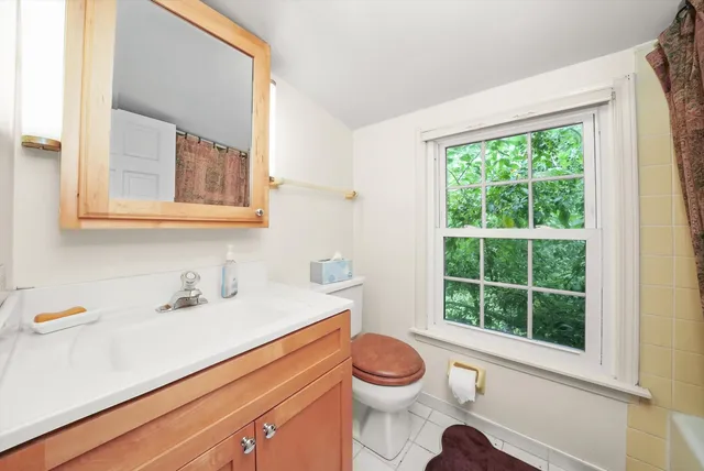 a bathroom with a sink a toilet and a window