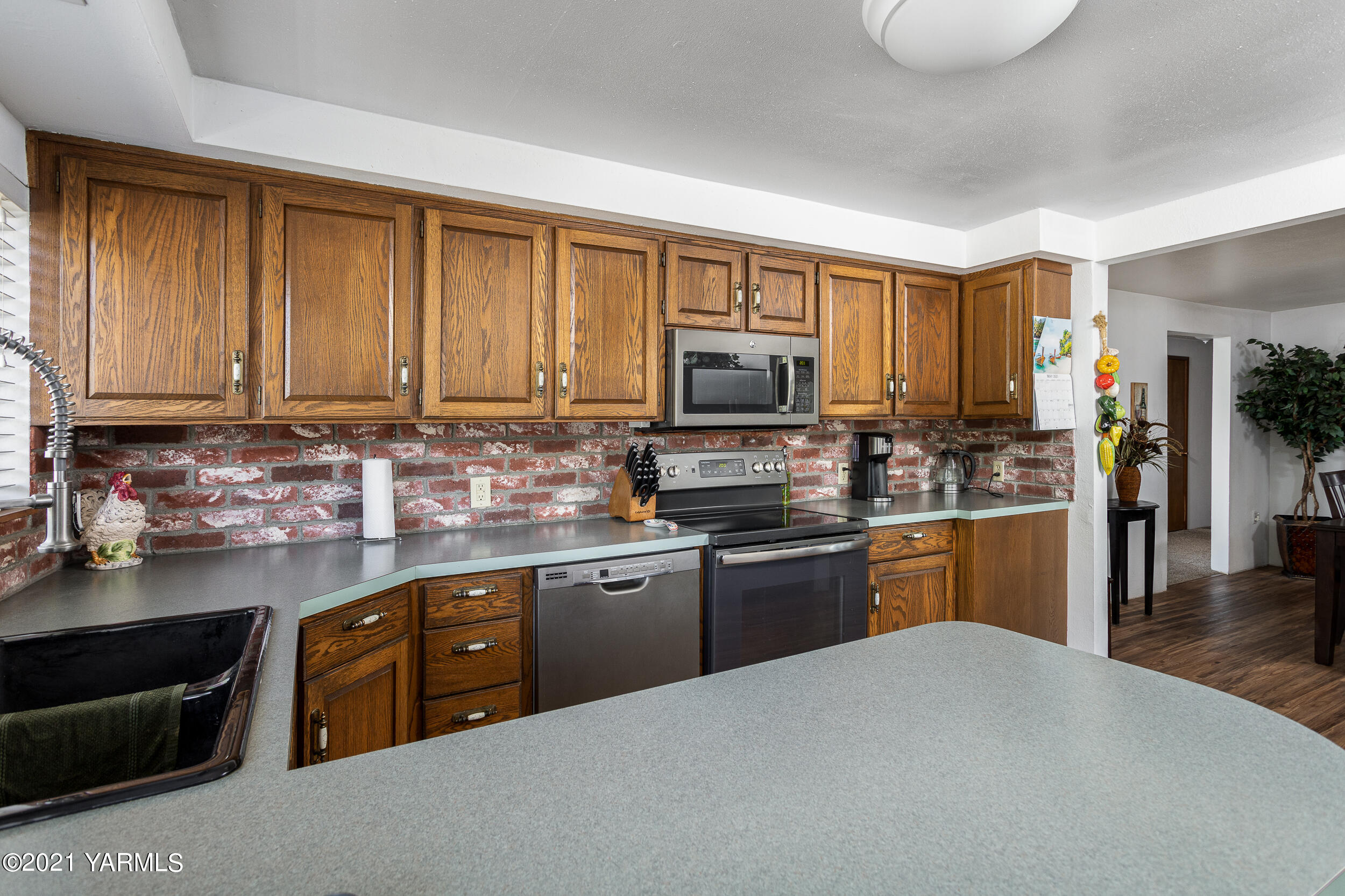 10605 Summitview Ext Road Yakima, WA 98908 - Photo 5 of 32 a kitchen with stainless steel appliances granite countertop a stove top oven a sink dishwasher a dining table and chairs with wooden floor