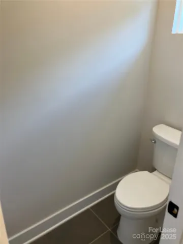 a white toilet sitting next to a white wall