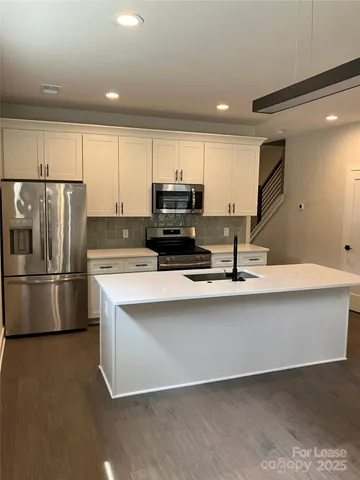 a kitchen with stainless steel appliances a refrigerator and a stove top oven