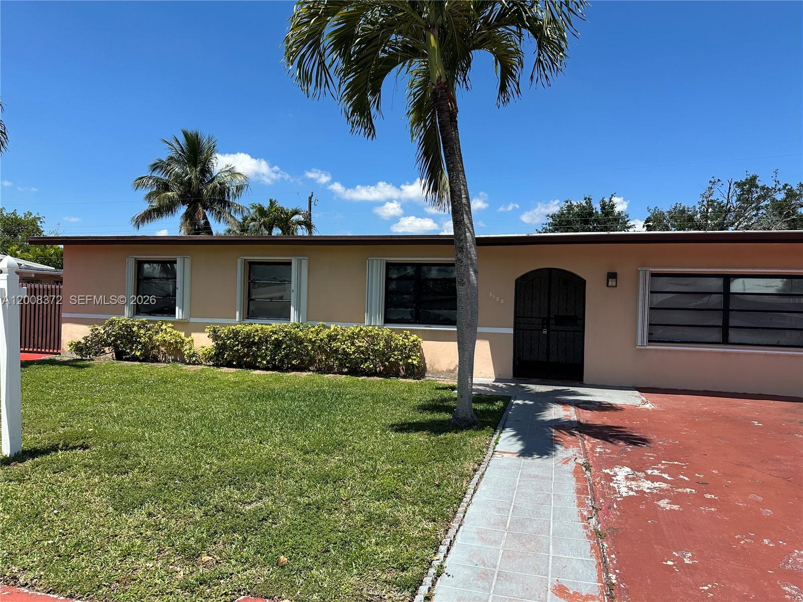 3100 Southwest 103rd Court Miami, FL 33165 - Photo 1 of 8 a front view of a house with a garden and yard