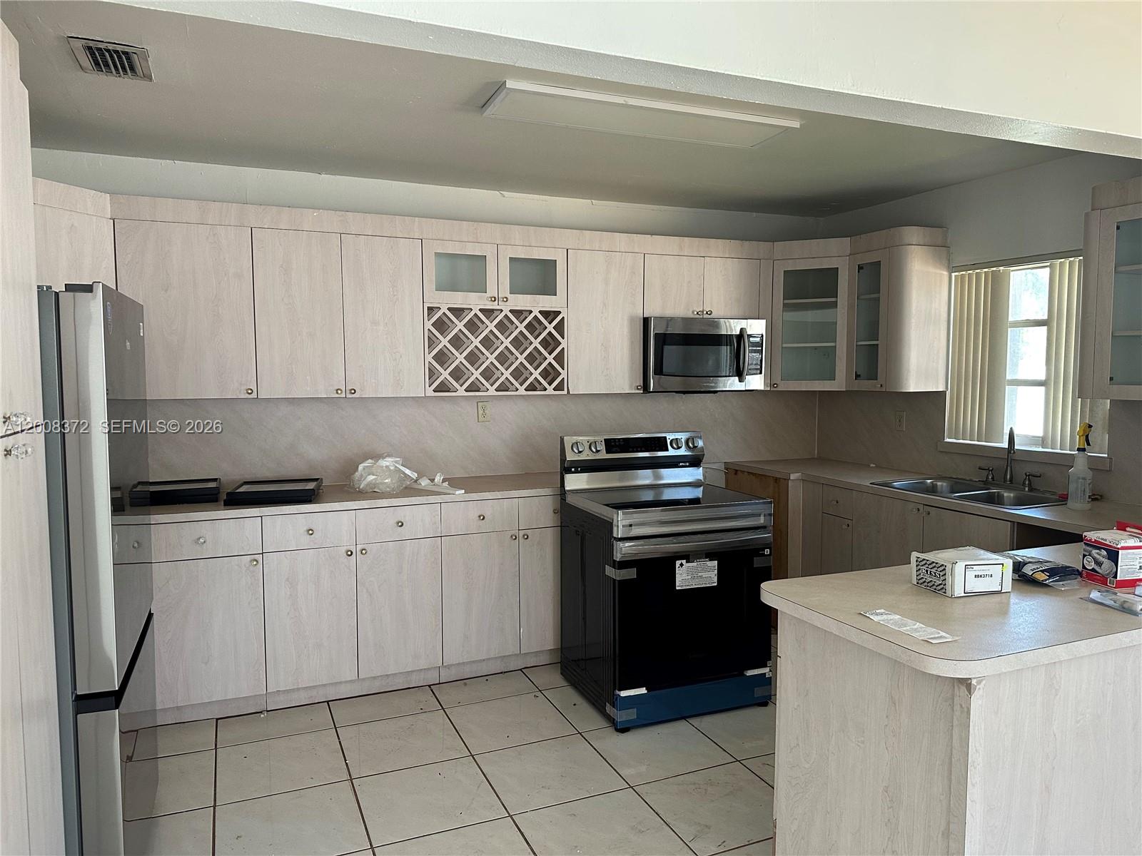 3100 Southwest 103rd Court Miami, FL 33165 - Photo 5 of 8 a kitchen with a sink appliances and cabinets