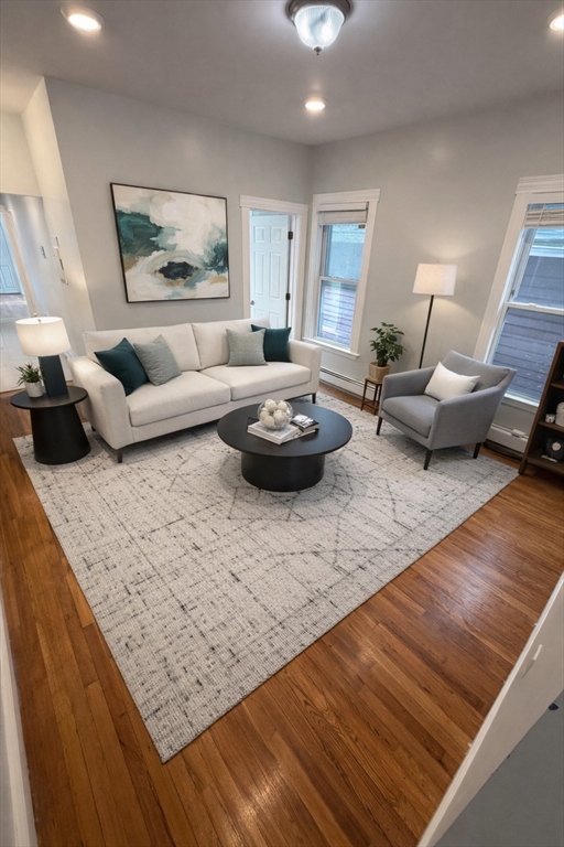 a living room with furniture and a wooden floor
