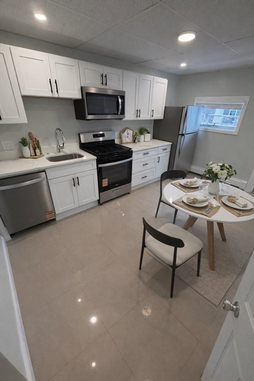 83 Chelsea Street, Unit 3 Boston, MA 02128 - Photo 2 of 8 a kitchen with stainless steel appliances a stove a sink a microwave a refrigerator and cabinets