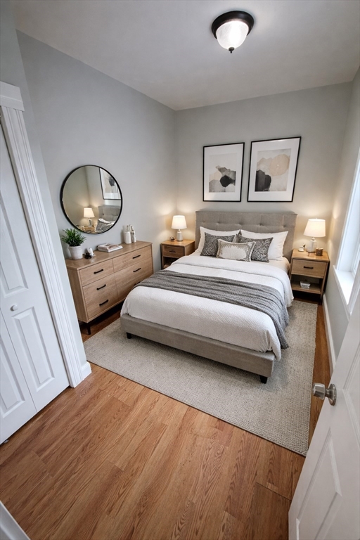 83 Chelsea Street, Unit 3 Boston, MA 02128 - Photo 3 of 8 a bedroom with a bed and a chandelier
