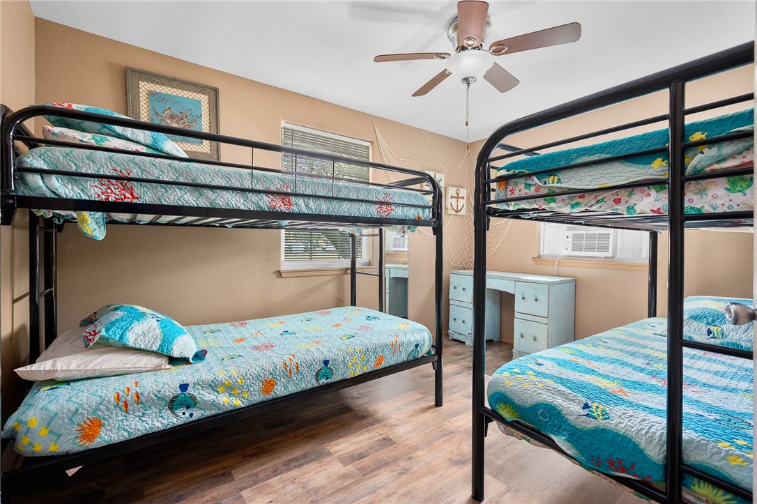 108 Palmetto Point Road Rockport, TX 78382 - Photo 21 of 22 a bedroom with a bed and a chandelier