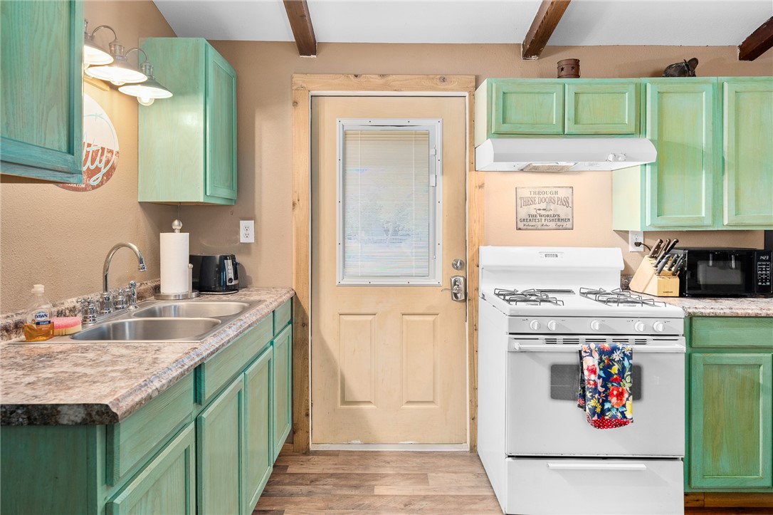 108 Palmetto Point Road Rockport, TX 78382 - Photo 7 of 22 a kitchen with kitchen island a stove a sink and a refrigerator