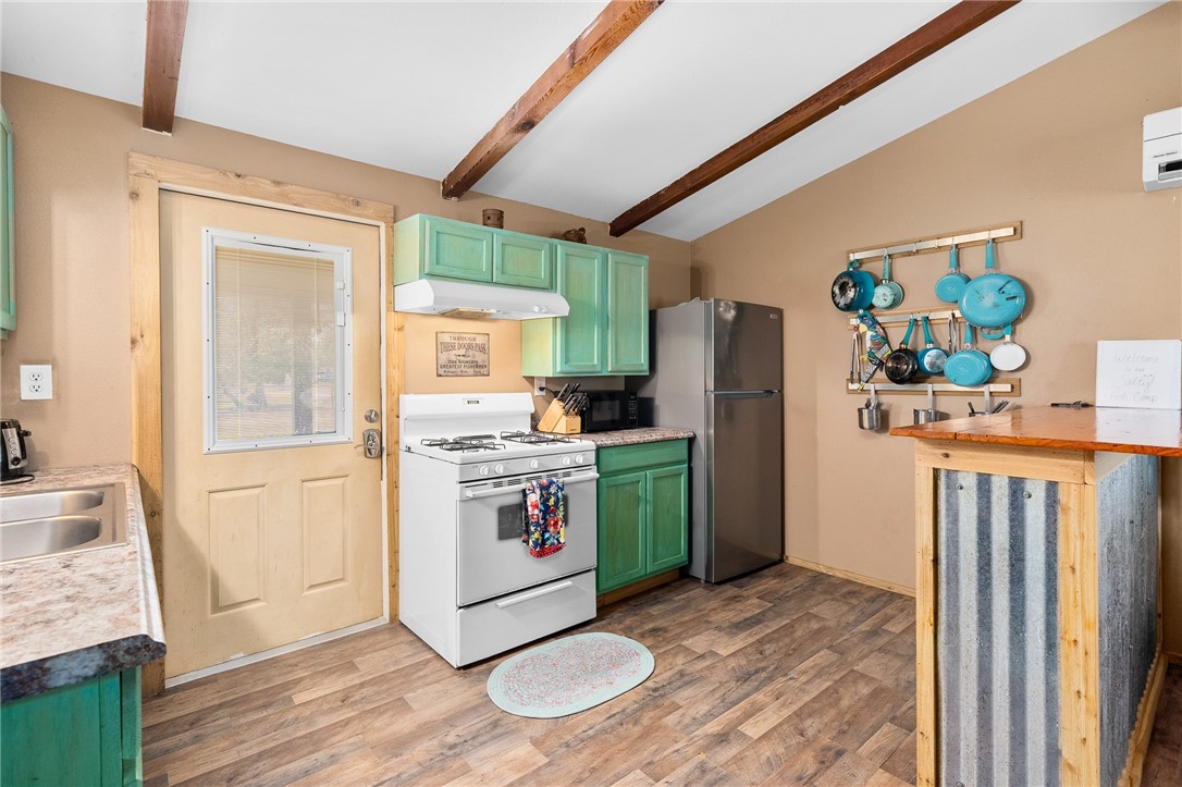 108 Palmetto Point Road Rockport, TX 78382 - Photo 9 of 22 a kitchen with a refrigerator a stove and wooden floor