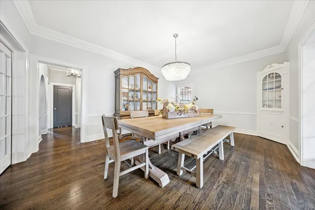 a view of a dining room with furniture a chandelier and wooden floor
