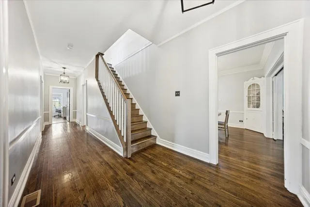 a view of a hallway with wooden floor and staircase