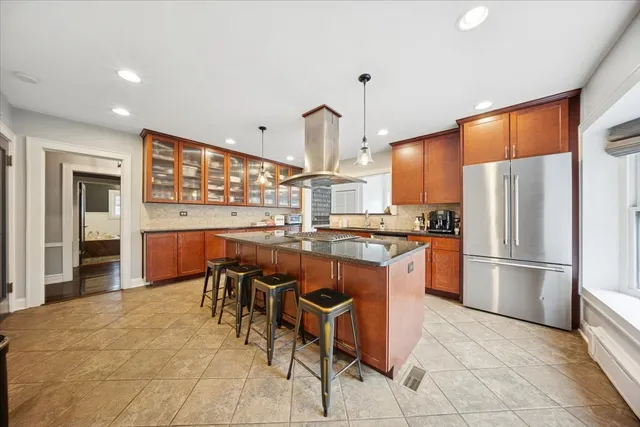 a kitchen with granite countertop a refrigerator a stove a sink and a dining table