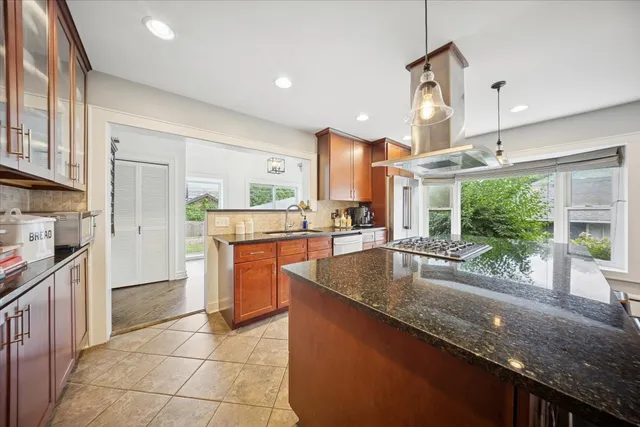 a kitchen with granite countertop a sink a counter top space appliances and cabinets