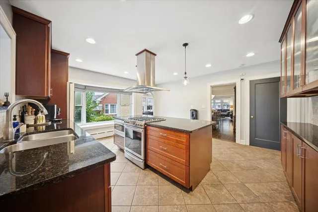 a kitchen with stainless steel appliances granite countertop a sink a stove and a refrigerator