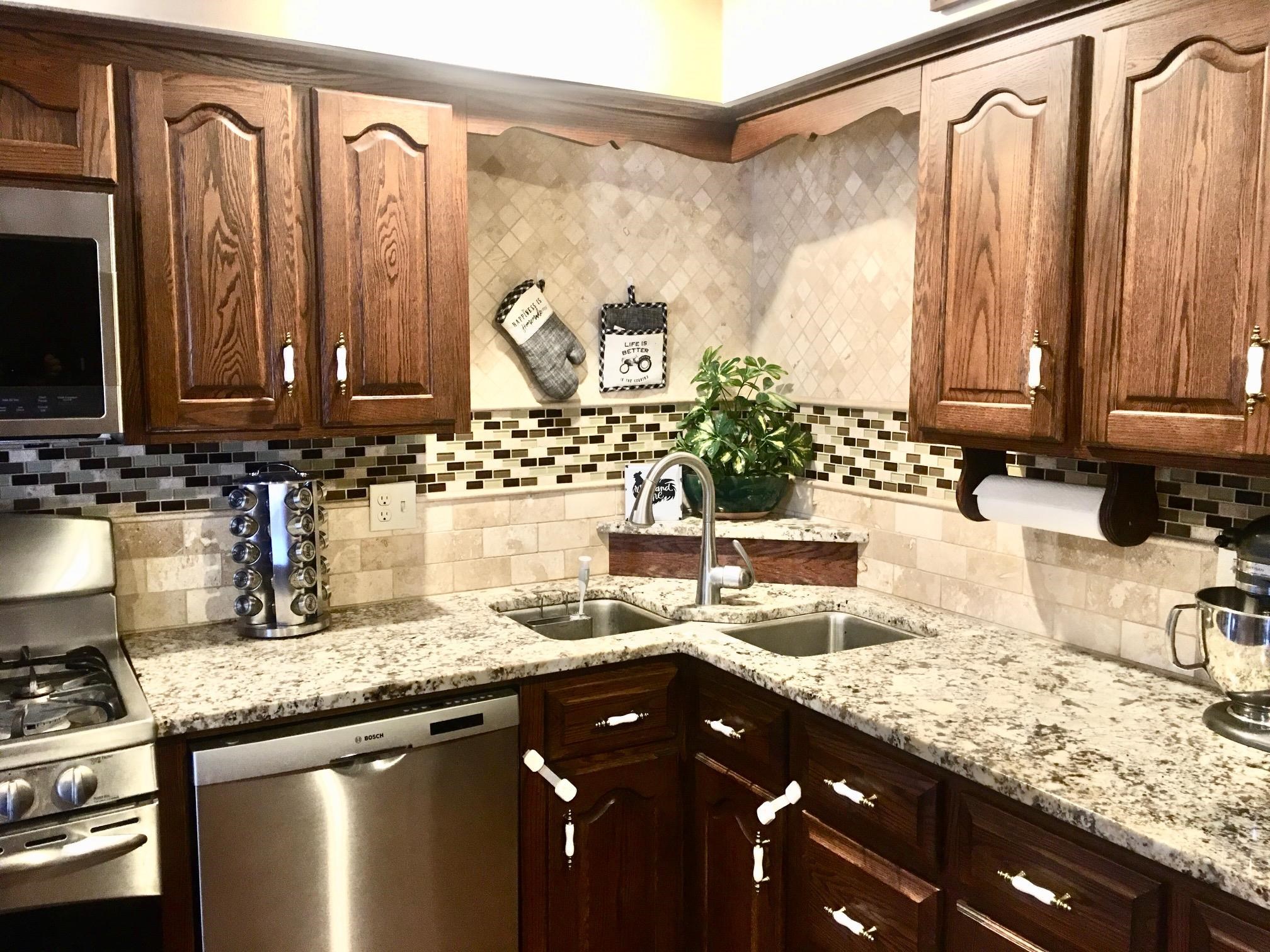 256 Spring Creek Road Rockford, IL 61114 - Photo 3 of 29 a kitchen with granite countertop a sink a stove and a wooden cabinets