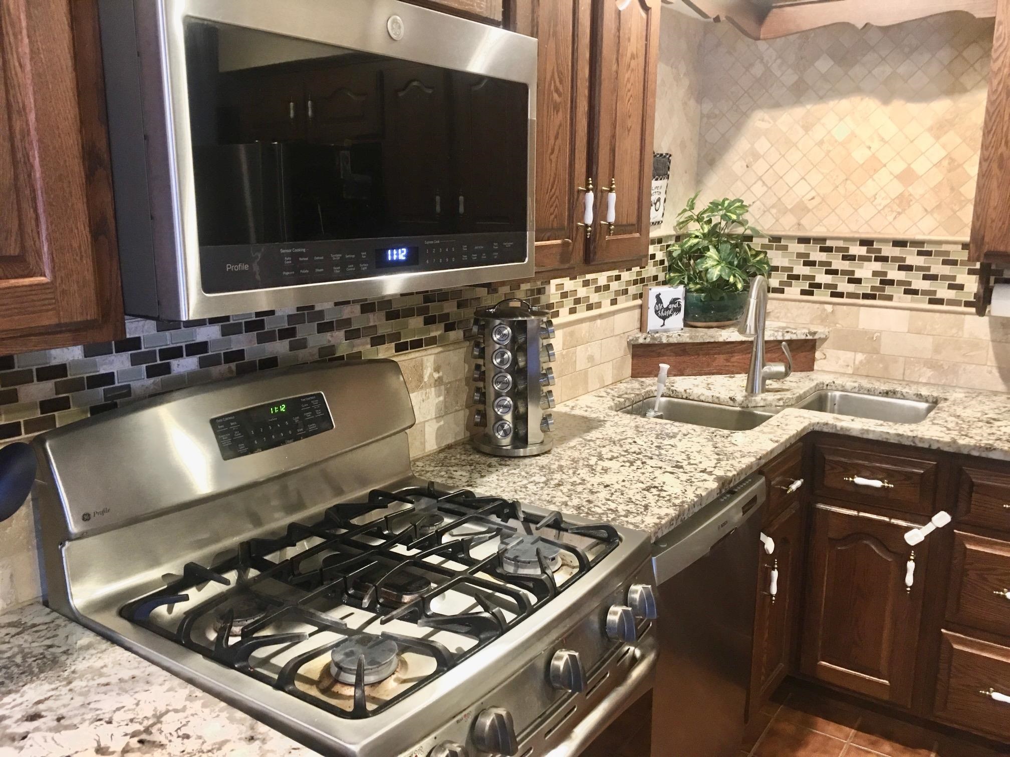 256 Spring Creek Road Rockford, IL 61114 - Photo 6 of 29 a kitchen with a stove a sink and a microwave