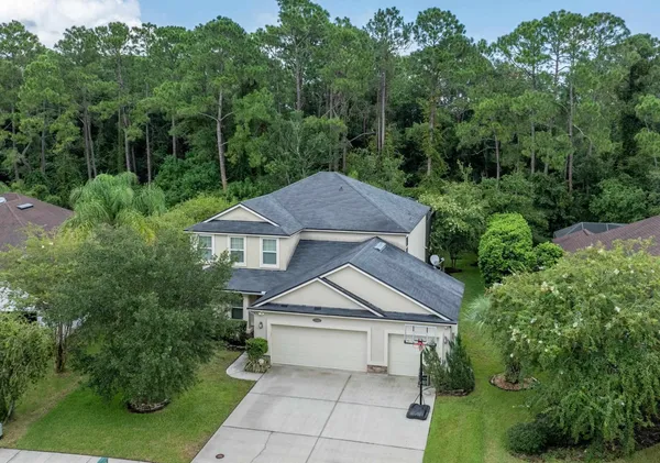 an aerial view of a house next to a yard