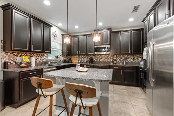 a kitchen with stainless steel appliances granite countertop a sink stove and refrigerator