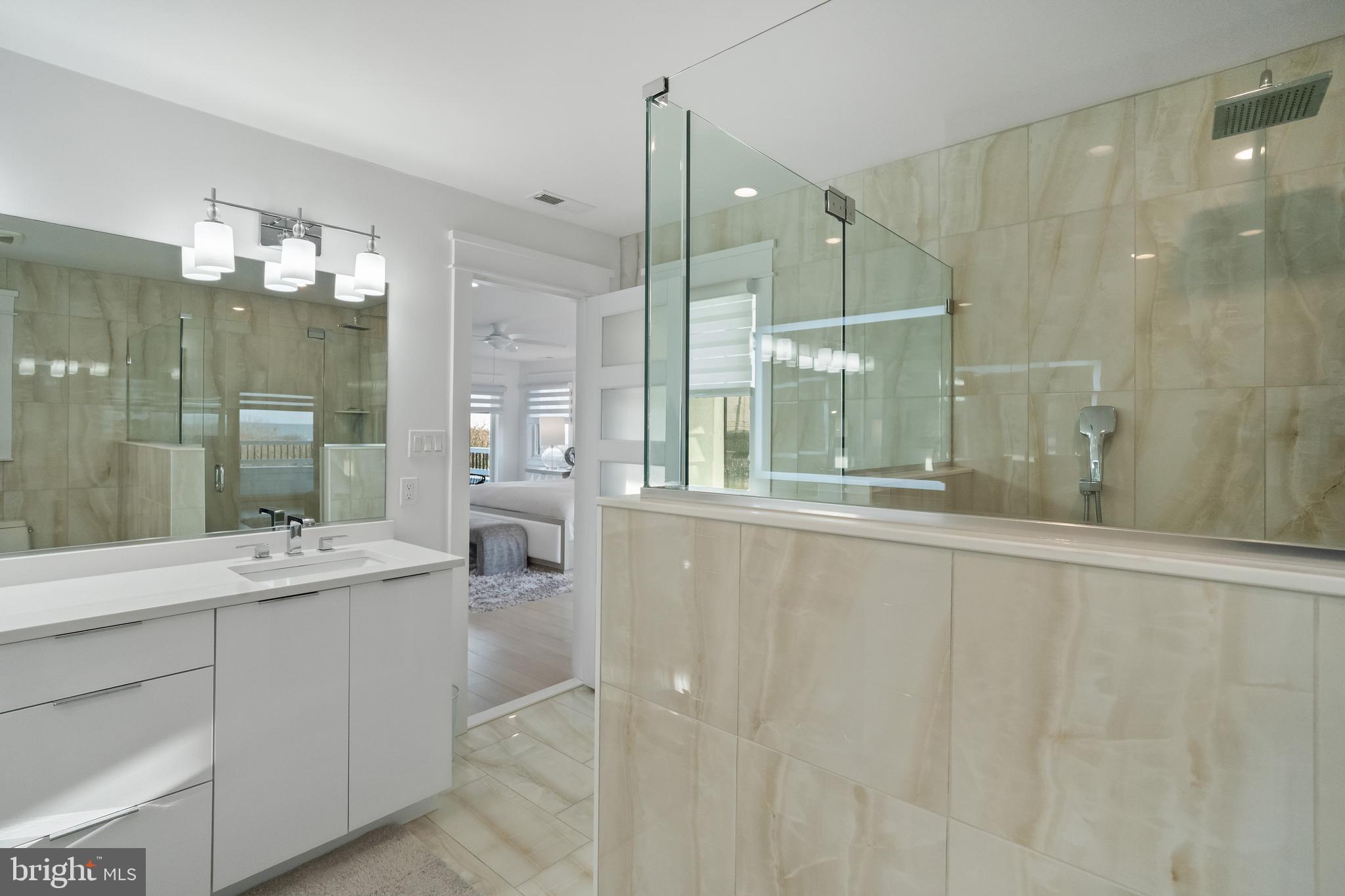 901 South Commonwealth Avenue, Unit SOUTH Strathmere, NJ 08248 - Photo 36 of 66 a bathroom with a double vanity sink mirror and shower