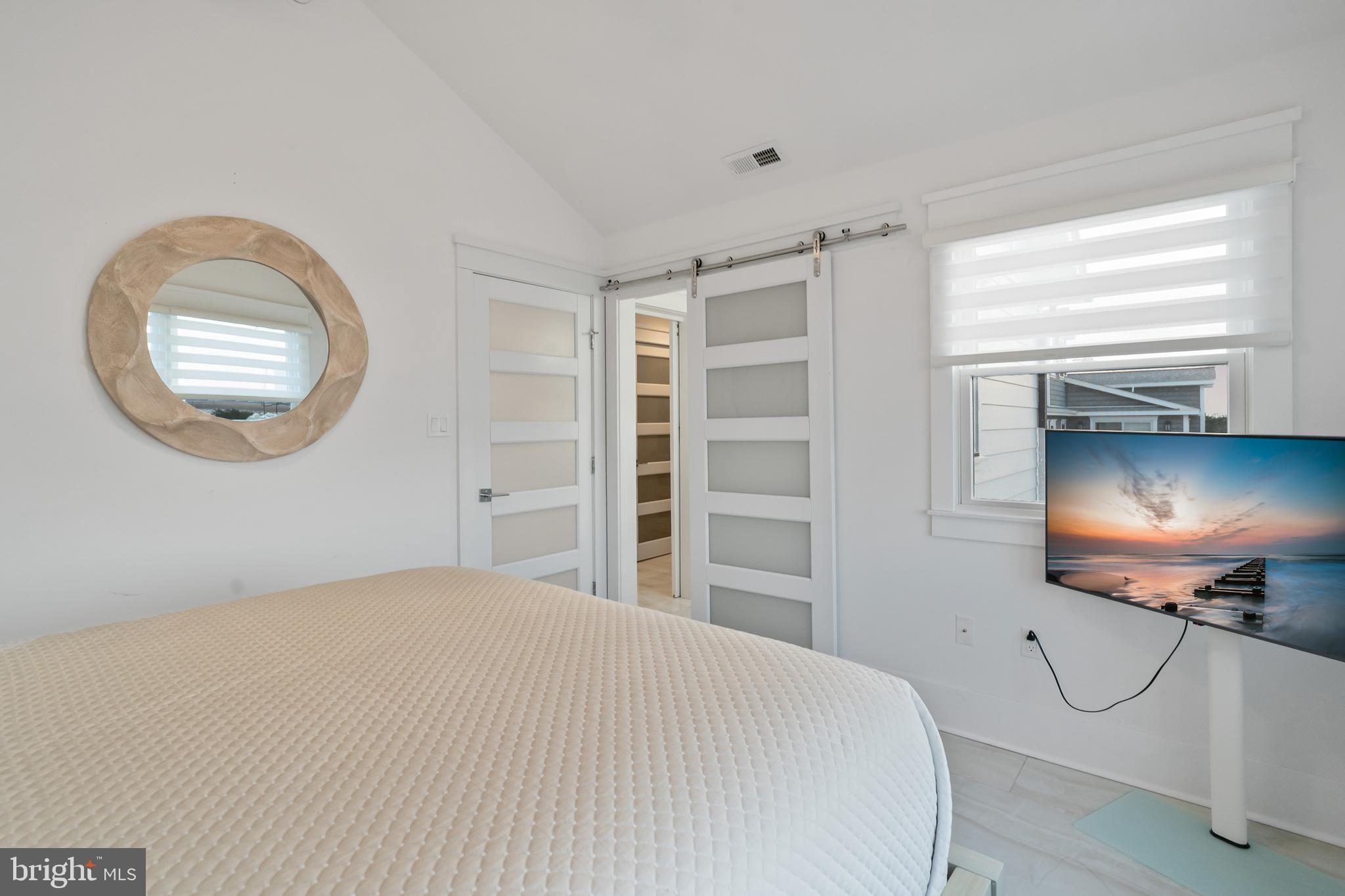 901 South Commonwealth Avenue, Unit SOUTH Strathmere, NJ 08248 - Photo 41 of 66 a bedroom with a bed and a chandelier