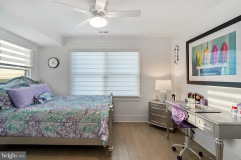 a spacious bedroom with a bed a couch and a lamp on table