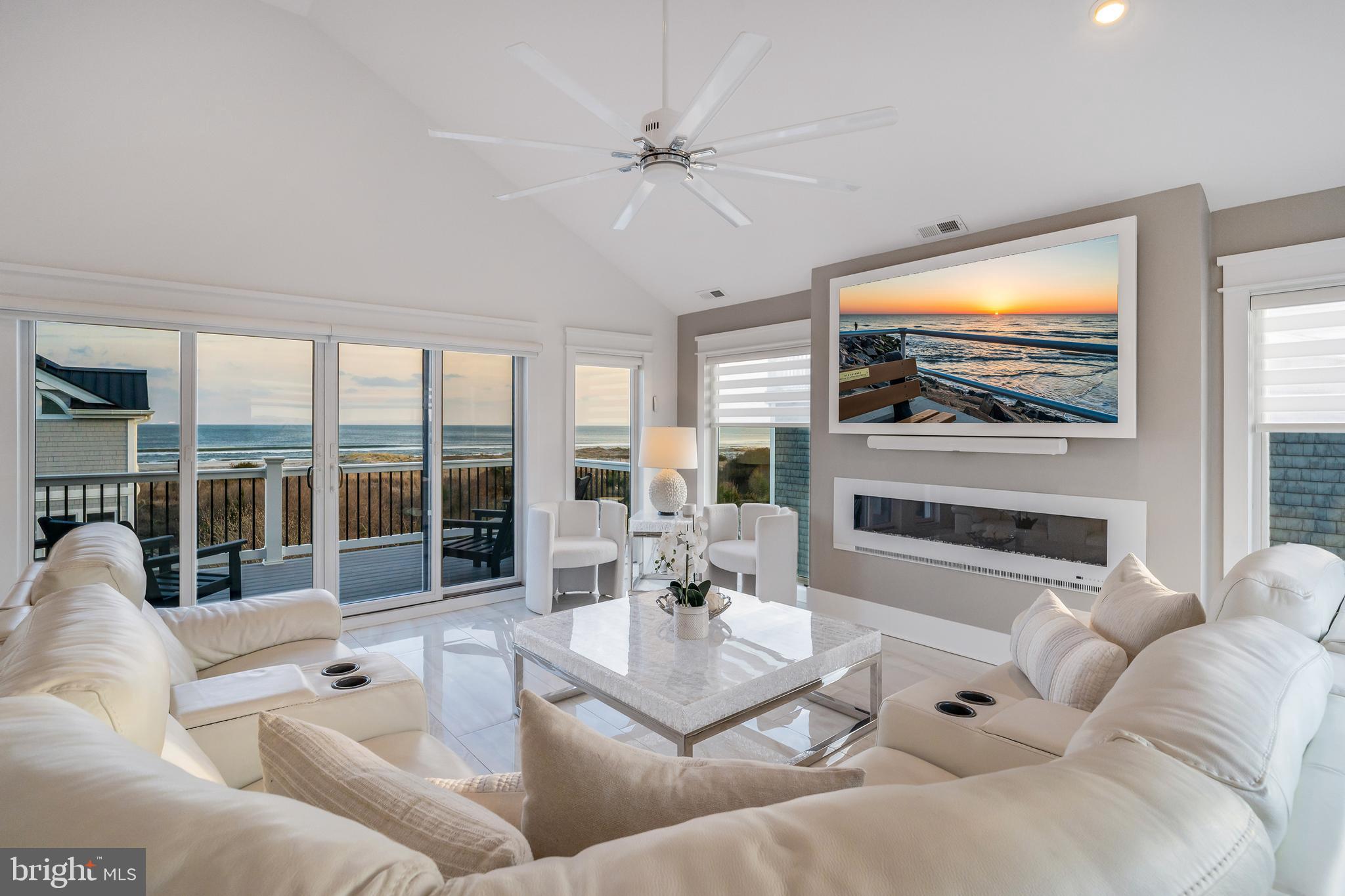 901 South Commonwealth Avenue, Unit SOUTH Strathmere, NJ 08248 - Photo 5 of 66 a living room with furniture a fireplace and a flat screen tv