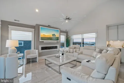 a living room with furniture large windows a rug and a fireplace